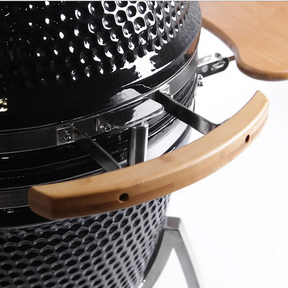 Close-up of a black grill with wooden handle on a white background