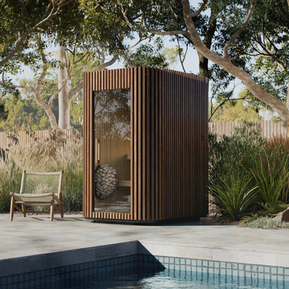 Wooden outdoor sauna cabin by a pool with a chair nearby