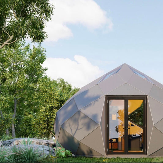 Geodesic dome structure with an open door, surrounded by trees and greenery